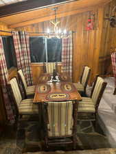 Furnished Dining room featuring wood ceiling, a notable chandelier, and wood walls