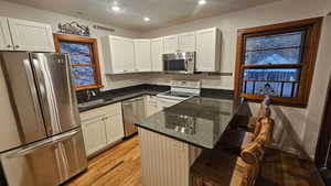 Kitchen with stainless steel appliances, sink, a breakfast bar area, and white cabinets