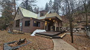 Log-style house featuring a wooden deck