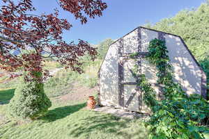 View of outbuilding with a lawn