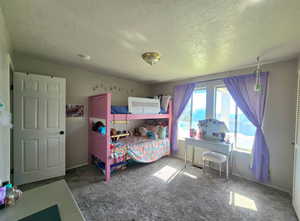 Bedroom with a textured ceiling and carpet