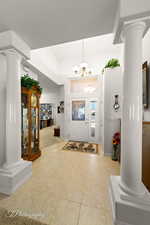 Entryway featuring a notable chandelier and ornate columns