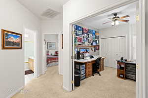 Carpeted office space featuring ceiling fan