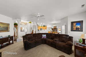 Living room featuring ceiling fan, light colored carpet, and decorative columns