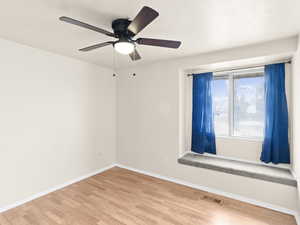 Spare room featuring wood-type flooring and ceiling fan