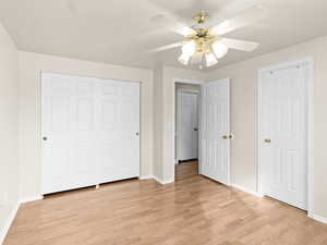 Unfurnished bedroom with a closet, ceiling fan, and light wood-type flooring