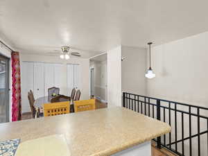 Kitchen with hardwood / wood-style flooring, ceiling fan, and hanging light fixtures