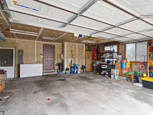 Garage featuring a garage door opener and electric panel