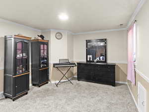 Miscellaneous room with crown molding and light colored carpet