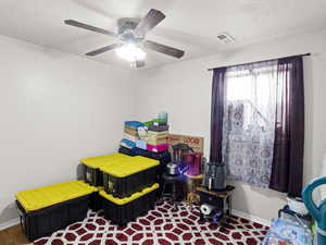 Bedroom with a textured ceiling and ceiling fan