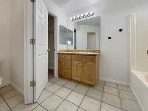 Bathroom with vanity, tile patterned floors, a bathtub, and toilet