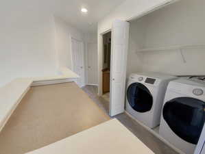 Clothes washing area featuring washing machine and clothes dryer