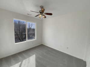 Carpeted spare room with ceiling fan