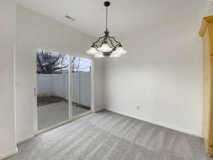 Empty room featuring a chandelier and carpet