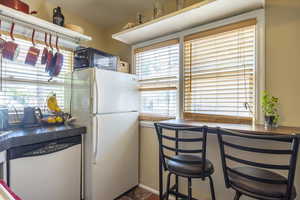 Kitchen with stainless steel dishwasher and white fridge