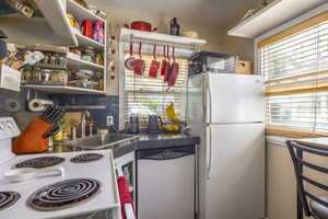 Kitchen with sink, white appliances, and decorative backsplash