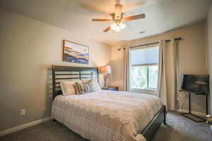 Carpeted bedroom with ceiling fan