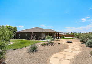 Rear view of house with a mountain view, a patio area, a fire pit, and a lawn