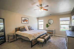 Bedroom with ceiling fan, carpet, and a textured ceiling