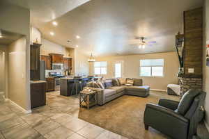 Living room featuring ceiling fan with notable chandelier, vaulted ceiling, and a textured ceiling