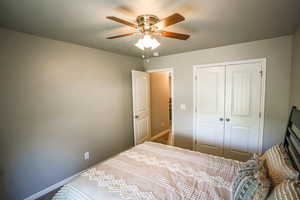 Bedroom featuring ceiling fan and a closet