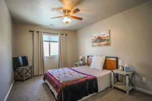 Bedroom featuring carpet, a textured ceiling, and ceiling fan