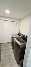 Laundry room featuring washer and dryer and light wood-type flooring