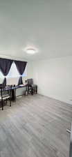 Sitting room with a textured ceiling and light hardwood / wood-style floors