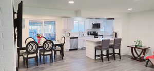 Kitchen with white cabinetry, sink, light wood-type flooring, and appliances with stainless steel finishes