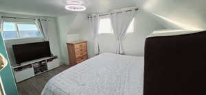 Bedroom with lofted ceiling and dark hardwood / wood-style flooring