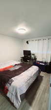 Bedroom featuring hardwood / wood-style floors and a textured ceiling