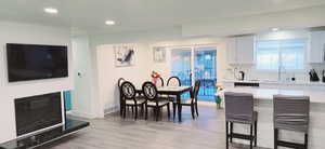 Dining room featuring sink, a fireplace, and light wood-type flooring