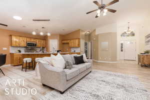 Living room featuring ceiling fan, high vaulted ceiling, and light wood-type flooring