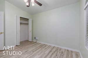 Unfurnished bedroom featuring lofted ceiling, light hardwood / wood-style floors, a closet, and ceiling fan