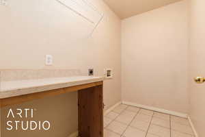 Laundry area with light tile patterned floors, hookup for a washing machine, and electric dryer hookup