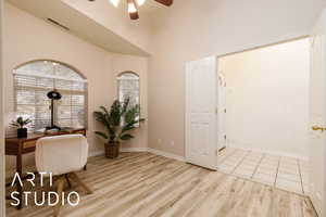 Office space with a high ceiling, ceiling fan, and light hardwood / wood-style flooring