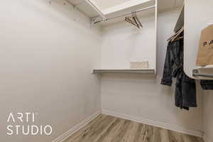 Spacious closet with hardwood / wood-style floors