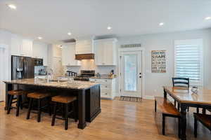 Kitchen with sink, stainless steel appliances, white cabinets, and a center island with sink