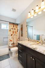 Full bathroom with vanity, shower / bath combination with curtain, and toilet