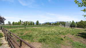 View of yard with a rural view, a mountain view, and an outdoor structure