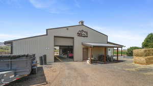 View of pole building with dirt driveway