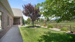Fenced backyard with a rural view and a patio