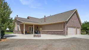 Ranch-style house with concrete driveway, roof with shingles, a garage, and board and batten siding