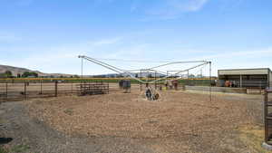 View of play area with an exterior structure, an outdoor structure, a mountain view, and a view of countryside