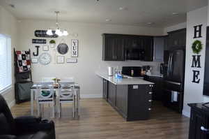 Kitchen with pendant lighting, a healthy amount of sunlight, sink, and black appliances