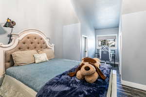 Bedroom with dark wood-type flooring and a textured ceiling