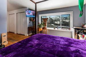 Bedroom featuring multiple closets, hardwood / wood-style flooring, and a textured ceiling