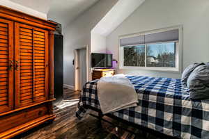 Bedroom with vaulted ceiling and hardwood / wood-style floors