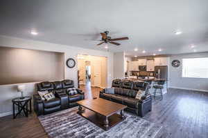 Living room with ceiling fan and dark hardwood / wood-style floors