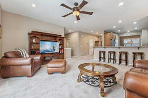 Carpeted living room featuring ceiling fan